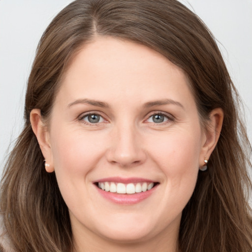 Joyful white young-adult female with long  brown hair and grey eyes