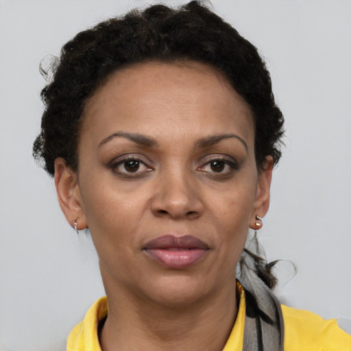 Joyful black adult female with short  brown hair and brown eyes