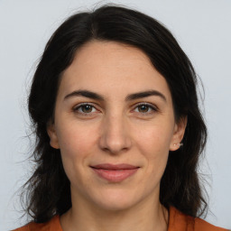 Joyful white adult female with long  brown hair and brown eyes