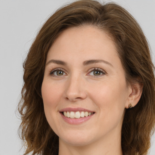 Joyful white young-adult female with long  brown hair and brown eyes