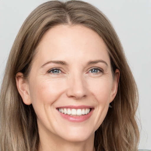 Joyful white adult female with long  brown hair and grey eyes