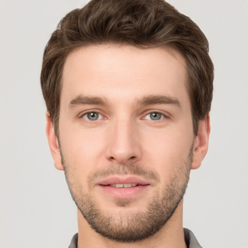 Joyful white young-adult male with short  brown hair and grey eyes