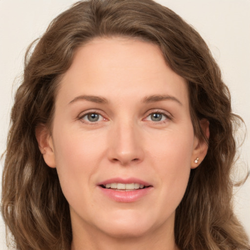 Joyful white young-adult female with long  brown hair and green eyes