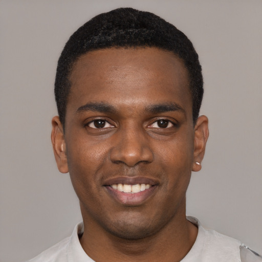 Joyful black young-adult male with short  black hair and brown eyes