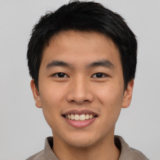 Joyful asian young-adult male with short  brown hair and brown eyes