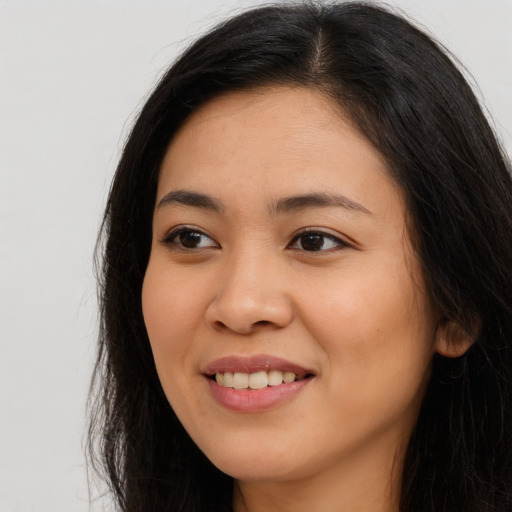 Joyful asian young-adult female with long  brown hair and brown eyes