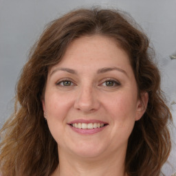 Joyful white adult female with long  brown hair and grey eyes