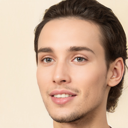 Joyful white young-adult male with long  brown hair and brown eyes