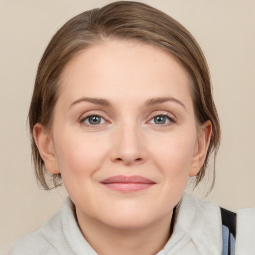 Joyful white young-adult female with medium  brown hair and blue eyes