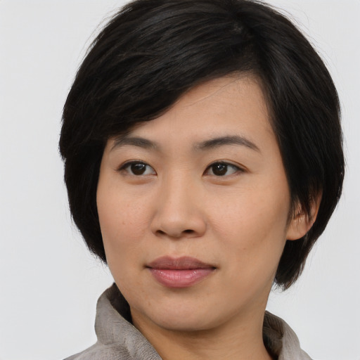 Joyful asian young-adult female with medium  black hair and brown eyes