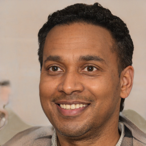 Joyful latino adult male with short  black hair and brown eyes