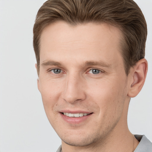 Joyful white young-adult male with short  brown hair and grey eyes