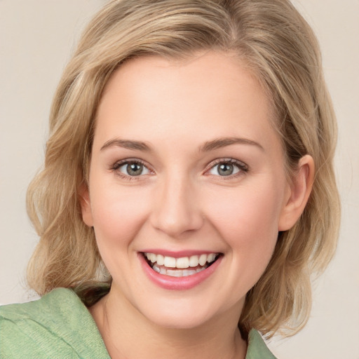 Joyful white young-adult female with medium  brown hair and green eyes