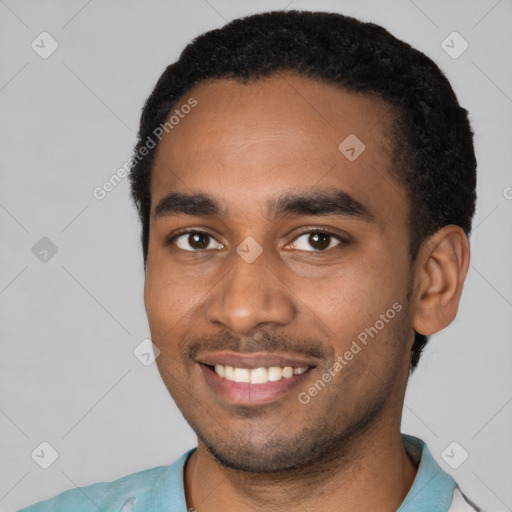 Joyful black young-adult male with short  black hair and brown eyes