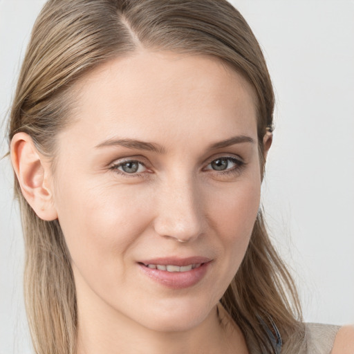 Joyful white young-adult female with long  brown hair and blue eyes