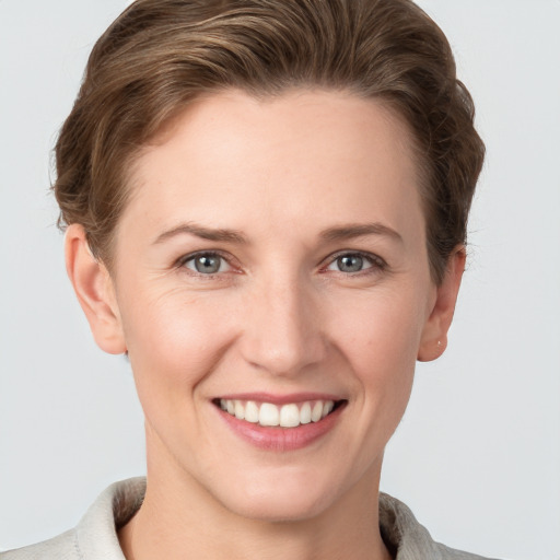 Joyful white young-adult female with short  brown hair and grey eyes