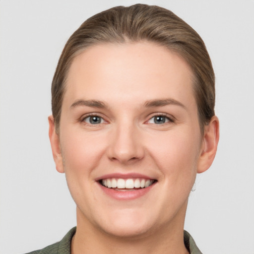 Joyful white young-adult female with short  brown hair and grey eyes