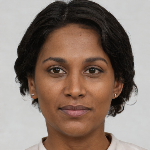 Joyful black young-adult female with short  brown hair and brown eyes