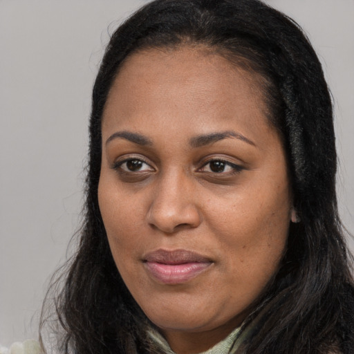 Joyful black young-adult female with long  brown hair and brown eyes