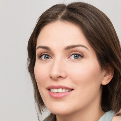 Joyful white young-adult female with medium  brown hair and green eyes