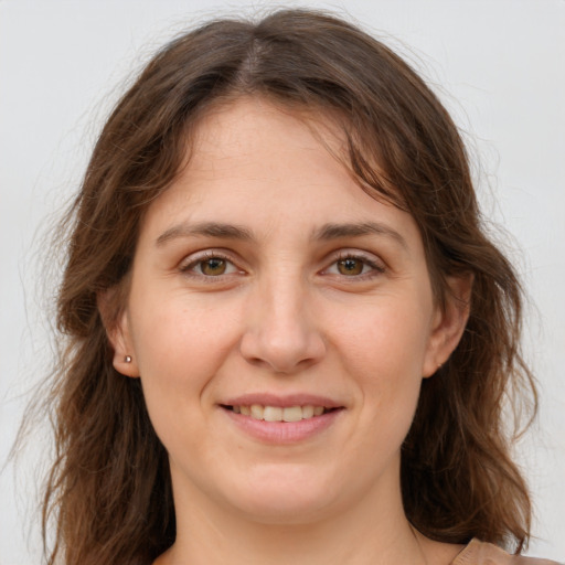 Joyful white young-adult female with long  brown hair and green eyes