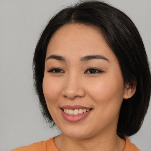 Joyful asian young-adult female with medium  black hair and brown eyes