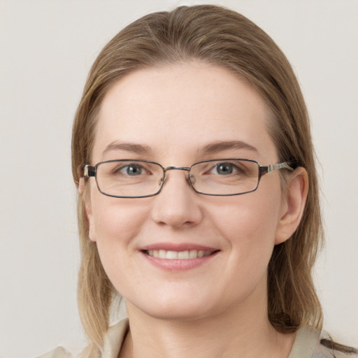 Joyful white young-adult female with medium  brown hair and grey eyes