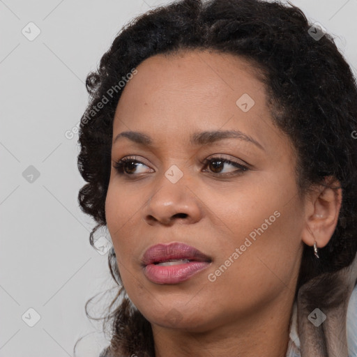 Joyful black young-adult female with long  brown hair and brown eyes