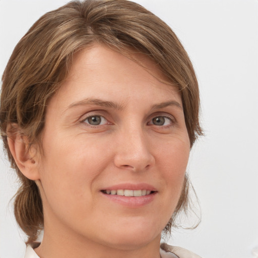 Joyful white adult female with medium  brown hair and grey eyes