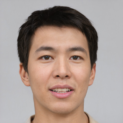 Joyful asian young-adult male with short  brown hair and brown eyes