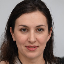 Joyful white adult female with long  brown hair and brown eyes