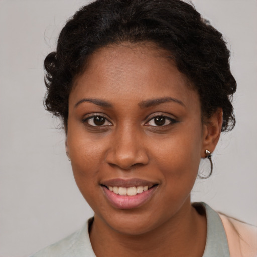 Joyful black young-adult female with medium  brown hair and brown eyes