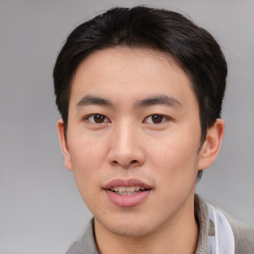 Joyful asian young-adult male with short  brown hair and brown eyes