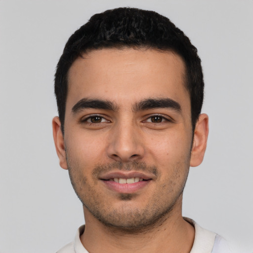 Joyful latino young-adult male with short  black hair and brown eyes