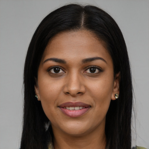 Joyful black young-adult female with long  brown hair and brown eyes