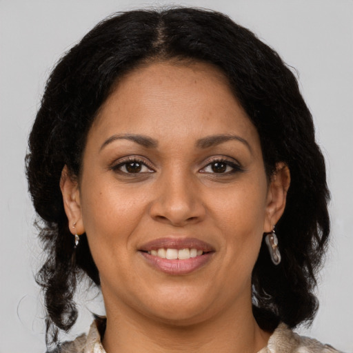 Joyful latino adult female with medium  brown hair and brown eyes