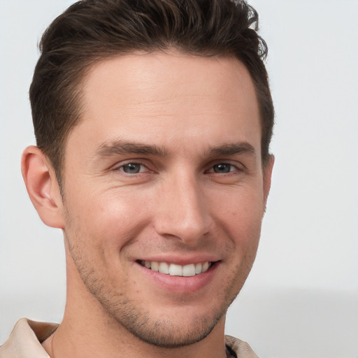 Joyful white young-adult male with short  brown hair and grey eyes