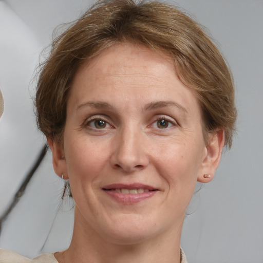 Joyful white adult female with medium  brown hair and grey eyes