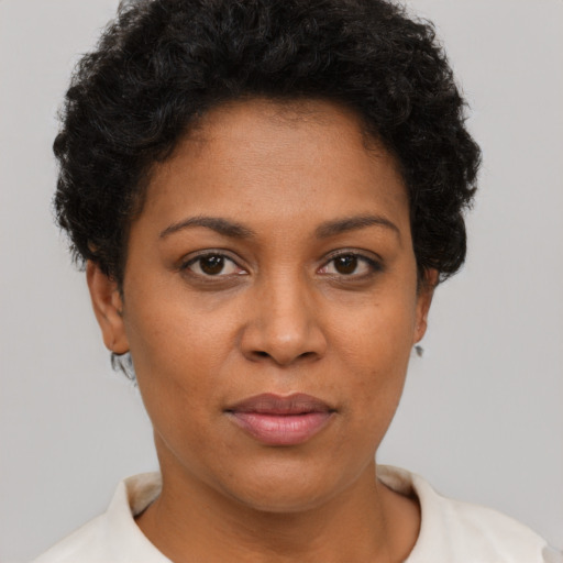 Joyful black young-adult female with short  brown hair and brown eyes