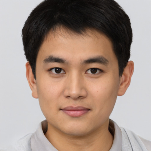 Joyful asian young-adult male with short  brown hair and brown eyes