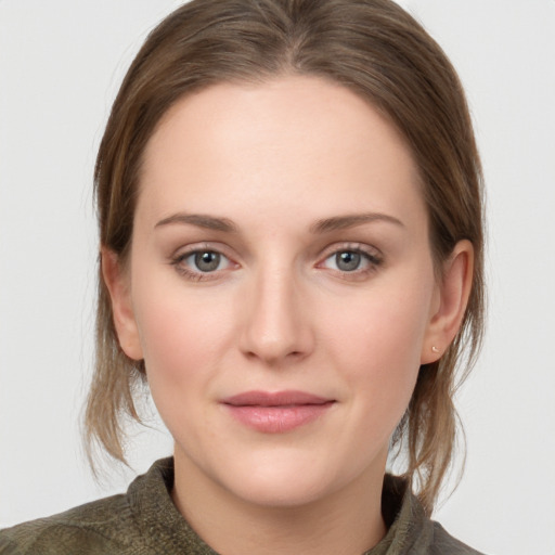 Joyful white young-adult female with medium  brown hair and grey eyes