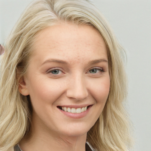 Joyful white young-adult female with long  blond hair and blue eyes