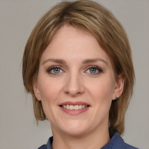 Joyful white young-adult female with medium  brown hair and blue eyes