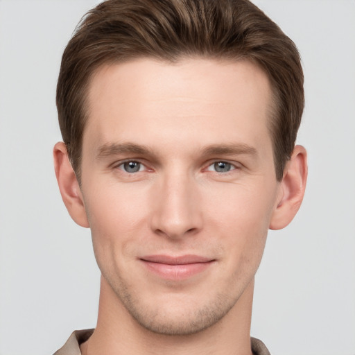 Joyful white young-adult male with short  brown hair and grey eyes