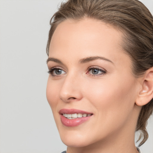 Joyful white young-adult female with medium  brown hair and grey eyes