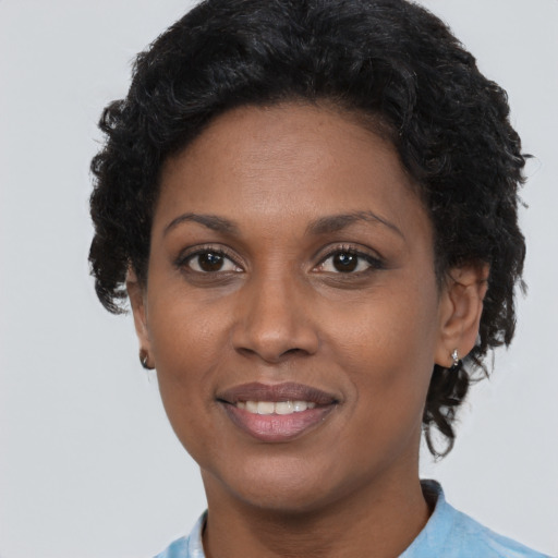 Joyful black adult female with short  brown hair and brown eyes