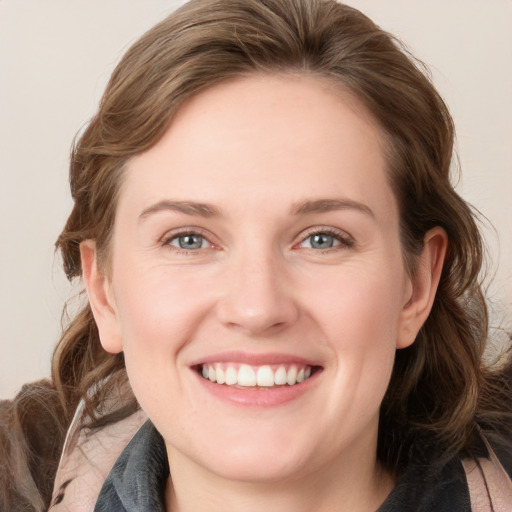 Joyful white young-adult female with medium  brown hair and grey eyes