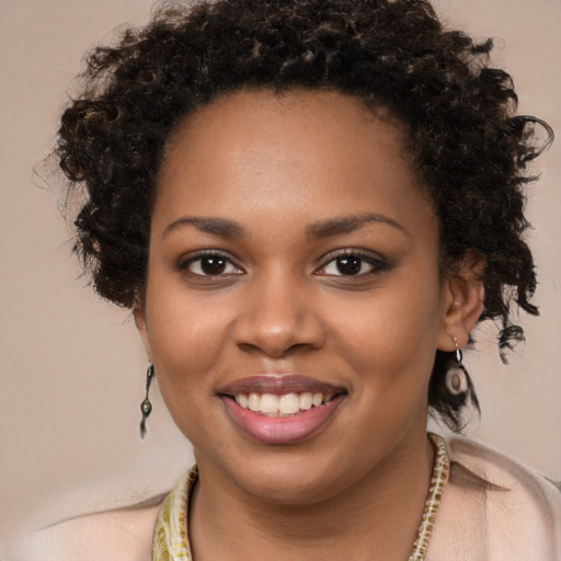 Joyful black young-adult female with long  brown hair and brown eyes