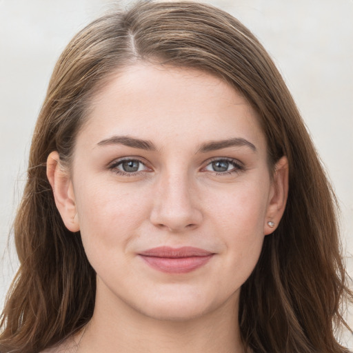 Joyful white young-adult female with long  brown hair and grey eyes