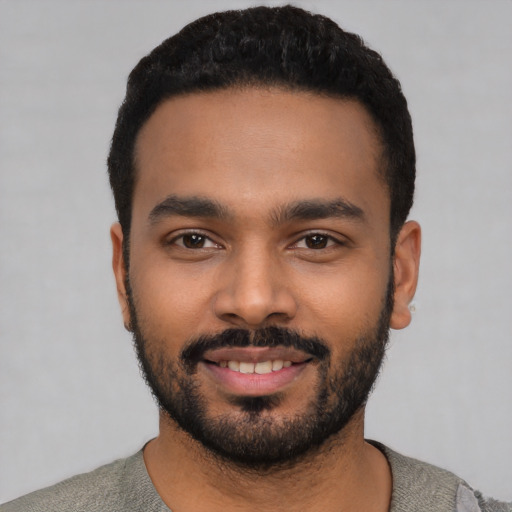 Joyful black young-adult male with short  black hair and brown eyes